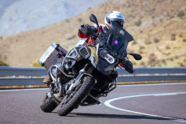 stock image motorcyclist taking a sharp curve on his bike. Photograph taken in the port of Navalmoral, province of the city of Avila, Spain, during the day September 9, 2020