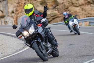 Motorsikletinde oturan bir adam, dağ yolunda keskin bir dönüş yapıyor. Fotoğraf Ağustos 2020 'de Avila şehrinde çekildi.