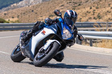 Motorcu motosikletiyle 10 Ağustos 2020 'de İspanya' nın Avila şehrinde bulunan Navalmoral limanında mavi gökyüzü ile güneşli bir günde motosikletine biniyor.