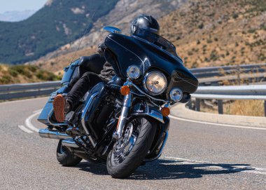 Motorcu motosikletiyle 10 Ağustos 2020 'de İspanya' nın Avila şehrinde bulunan Navalmoral limanında mavi gökyüzü ile güneşli bir günde motosikletine biniyor.