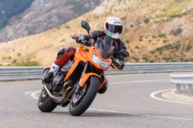 Motorcu motosikletiyle 10 Ağustos 2020 'de İspanya' nın Avila şehrinde bulunan Navalmoral limanında mavi gökyüzü ile güneşli bir günde motosikletine biniyor.