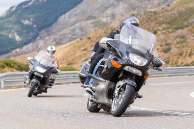 Motorcu motosikletiyle 10 Ağustos 2020 'de İspanya' nın Avila şehrinde bulunan Navalmoral limanında mavi gökyüzü ile güneşli bir günde motosikletine biniyor.