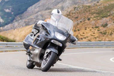 Motorcu motosikletiyle 10 Ağustos 2020 'de İspanya' nın Avila şehrinde bulunan Navalmoral limanında mavi gökyüzü ile güneşli bir günde motosikletine biniyor.