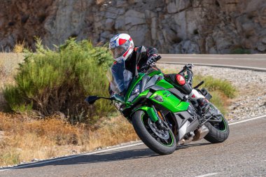 22 Ağustos 2020 'de İspanya' nın Avila şehrinde çekilen ve Navalmoral limanı adı verilen virajlı bir yolda motosikletine binen bir adam.