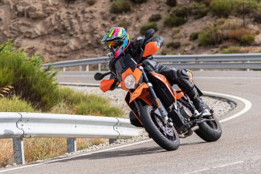 22 Ağustos 2020 'de İspanya' nın Avila şehrinde çekilen ve Navalmoral limanı adı verilen virajlı bir yolda motosikletine binen bir adam.