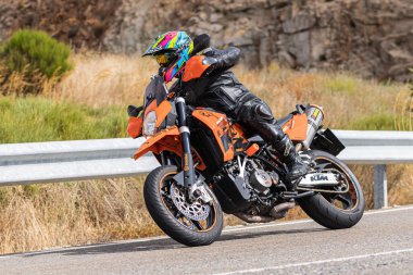 22 Ağustos 2020 'de İspanya' nın Avila şehrinde çekilen ve Navalmoral limanı adı verilen virajlı bir yolda motosikletine binen bir adam.