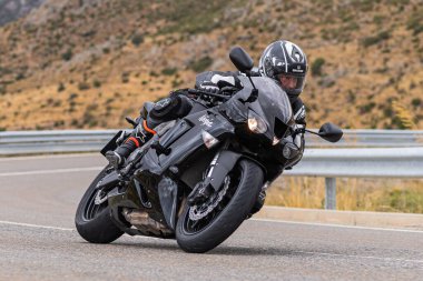 22 Ağustos 2020 'de İspanya' nın Avila şehrinde çekilen ve Navalmoral limanı adı verilen virajlı bir yolda motosikletine binen bir adam.