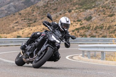 22 Ağustos 2020 'de İspanya' nın Avila şehrinde çekilen ve Navalmoral limanı adı verilen virajlı bir yolda motosikletine binen bir adam.