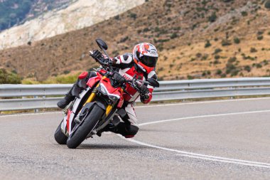 22 Ağustos 2020 'de İspanya' nın Avila şehrinde çekilen ve Navalmoral limanı adı verilen virajlı bir yolda motosikletine binen bir adam.