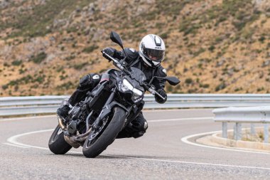 22 Ağustos 2020 'de İspanya' nın Avila şehrinde çekilen ve Navalmoral limanı adı verilen virajlı bir yolda motosikletine binen bir adam.