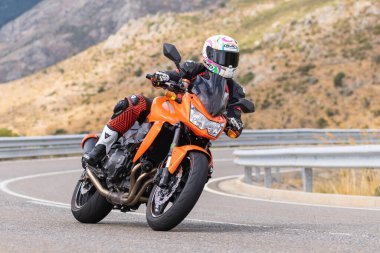 22 Ağustos 2020 'de İspanya' nın Avila şehrinde çekilen ve Navalmoral limanı adı verilen virajlı bir yolda motosikletine binen bir adam.