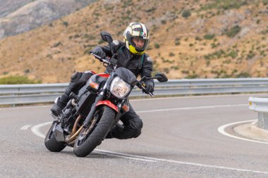 22 Ağustos 2020 'de İspanya' nın Avila şehrinde çekilen ve Navalmoral limanı adı verilen virajlı bir yolda motosikletine binen bir adam.