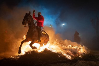 Atlısıyla birlikte Piorno 'nun alevlerinin üzerinden geçerken. Ocak gecesi İspanya 'nın Avila kentindeki San Bartolom de Pinares kasabasında düzenlenen kutlama, hayvanların arındırılması için düzenlendi.