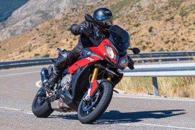 İspanya 'nın Avila ilinde Navalmoral limanında motosikletinin üzerinde oturan bir adam. Fotoğraf Ağustos 2020 'de çekildi