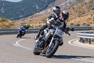 İspanya 'nın Avila ilinde Navalmoral limanında motosikletinin üzerinde oturan bir adam. Fotoğraf Ağustos 2020 'de çekildi