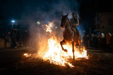 rider mounted on his horse, which is next to the fire. photograph taken on January 16, 2025 in the town of San Bartolome de Pinares, vila (Spain) in its traditional festival called las luminarias. clipart