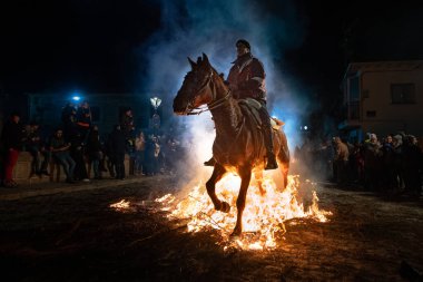 rider mounted on his horse, which is next to the fire. photograph taken on January 16, 2025 in the town of San Bartolome de Pinares, vila (Spain) in its traditional festival called las luminarias. clipart