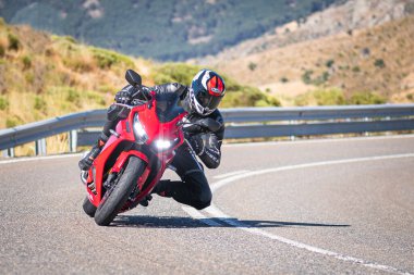 Motista ayık su vehculo, inclinando la motocicleta en una curva pronunciada. Fotografa tomada durante el mes de agosto del ao 2020 en la localidad de Navalmoral de la sierra, avila, İspanya