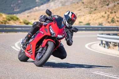 Motista ayık su vehculo, inclinando la motocicleta en una curva pronunciada. Fotografa tomada durante el mes de agosto del ao 2020 en la localidad de Navalmoral de la sierra, avila, İspanya