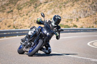 Motista ayık su vehculo, inclinando la motocicleta en una curva pronunciada. Fotografa tomada durante el mes de agosto del ao 2020 en la localidad de Navalmoral de la sierra, avila, İspanya
