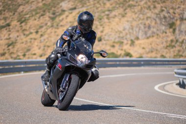Motista ayık su vehculo, inclinando la motocicleta en una curva pronunciada. Fotografa tomada durante el mes de agosto del ao 2020 en la localidad de Navalmoral de la sierra, avila, İspanya