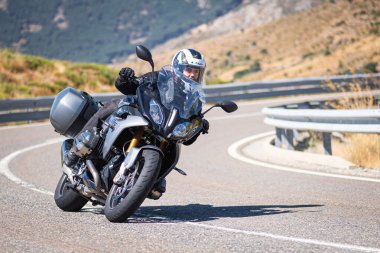 Motista ayık su vehculo, inclinando la motocicleta en una curva pronunciada. Fotografa tomada durante el mes de agosto del ao 2020 en la localidad de Navalmoral de la sierra, avila, İspanya