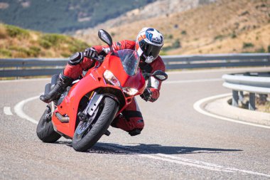 Motista ayık su vehculo, inclinando la motocicleta en una curva pronunciada. Fotografa tomada durante el mes de agosto del ao 2020 en la localidad de Navalmoral de la sierra, avila, İspanya