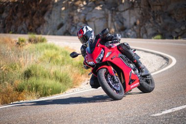 Güneşli bir günde 8 Ağustos 2020 tarihinde İspanya 'nın Avila ilinin Navalmoral de la Sierra limanında tehlikeli bir viraj alan motosikletçi