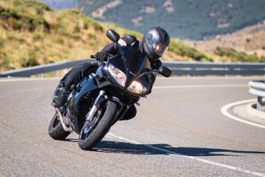 Güneşli bir günde 8 Ağustos 2020 tarihinde İspanya 'nın Avila ilinin Navalmoral de la Sierra limanında tehlikeli bir viraj alan motosikletçi