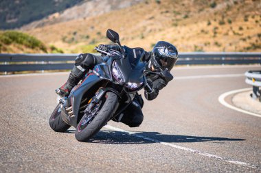 Güneşli bir günde 8 Ağustos 2020 tarihinde İspanya 'nın Avila ilinin Navalmoral de la Sierra limanında tehlikeli bir viraj alan motosikletçi