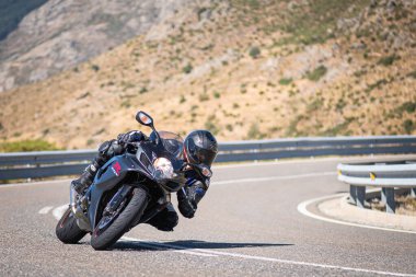Güneşli bir günde 8 Ağustos 2020 tarihinde İspanya 'nın Avila ilinin Navalmoral de la Sierra limanında tehlikeli bir viraj alan motosikletçi
