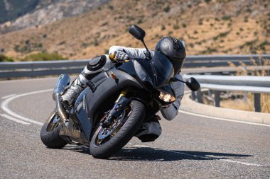 Motosikletli motorsikletli araca doğru keskin bir dönüş yapıyor.