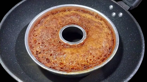 Gümüş tavada Karamelli Endonezya Keki ve izole edilmiş Kara Arkaplan.