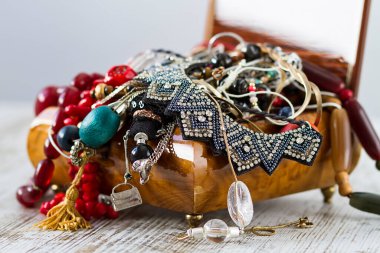 Kolye ve kostüm mücevherleriyle dolu antik ahşap bir mücevher kutusu.