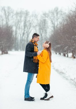 Sokağın ortasında el ele tutuşan aşık çiftlerin romantik kış buluşması. Mutlu çift kışın dışarıda sarılıp gülüyor. Sevgililer Günü