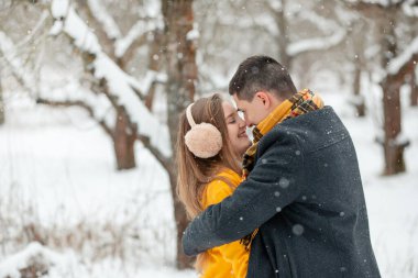 Sokağın ortasında el ele tutuşan aşık çiftlerin romantik kış buluşması. Mutlu çift kışın dışarıda sarılıp gülüyor. Sevgililer Günü