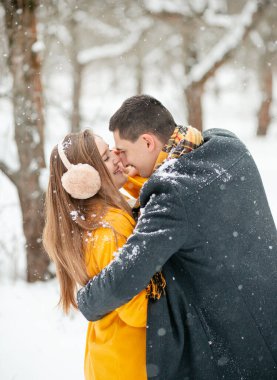 Sokağın ortasında el ele tutuşan aşık çiftlerin romantik kış buluşması. Mutlu çift kışın dışarıda sarılıp gülüyor. Sevgililer Günü