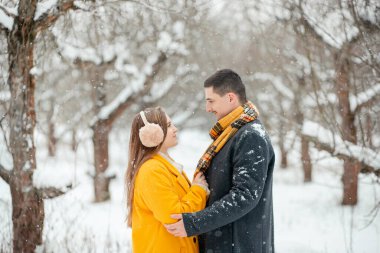 Sokağın ortasında el ele tutuşan aşık çiftlerin romantik kış buluşması. Mutlu çift kışın dışarıda sarılıp gülüyor. Sevgililer Günü