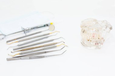 Diş muayenesi konsepti. Diş fırçası, diş fırçası ve yüz maskesi beyaz arka planda, düz yerde. Metin için yer.