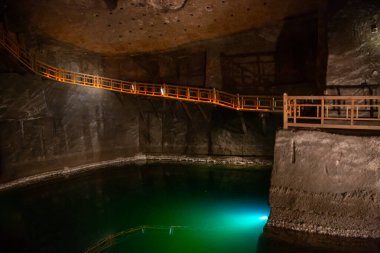 WIELICZKA, POLAND - 30 Haziran Yeraltı merdiveni ve Wieliczka tuz mağarası gölü. Wieliczka ve Bochnia kraliyet tuz madenlerinin iç manzarası tuz duvarları ve tavan, yapay ışıklarla loş aydınlatılıyor.