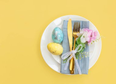 Mutlu Paskalyalar. Paskalya kutlaması. Üst manzara dikey peçete boş beyaz ve sarı plaka, paskalya yumurtaları, izole sarı arka plan. Boşluğu kopyala, metin için yer, pankart.