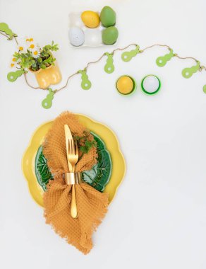 Mutlu Paskalyalar. Paskalya kutlaması. Üst manzara dikey peçete boş yeşil ve sarı plaka, paskalya yumurtaları, izole beyaz arka plan. Boşluğu kopyala, metin için yer, pankart.