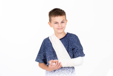 Kapalı portre çocuk, el bandajı beyaz arka plan konsepti, çocuk eli yaralanması ve bandaj sargısı. Kırık eli ya da el çıkığı olan çocuk beyaz arka planda izole edildi.