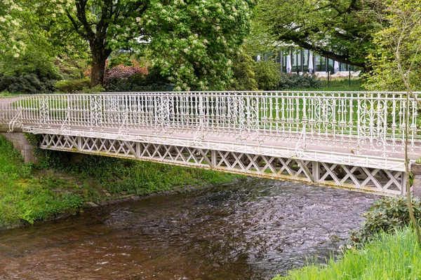 公園内の川にかかる白い鉄橋 — ストック写真