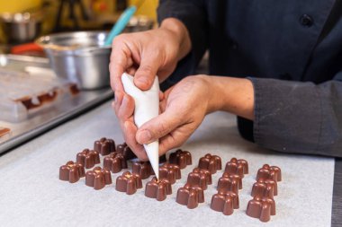 Çikolata boruları çikolataya doluyor, ağız sulandırıcı bir görüntü yaratıyor. El yapımı hediyeler kutlamalar ya da özel günlerde verilen hediyeler için mükemmeldir. Seçici odak