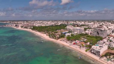 Turkuaz sular, otellerle ve otellerle dolu güzel bir plajı kaplıyor.