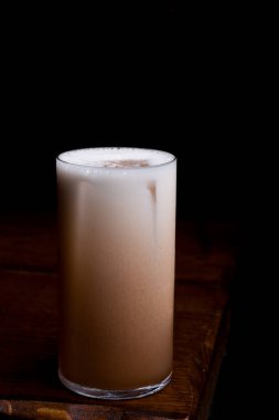 Arka planda bir bardak buzlu kahve.