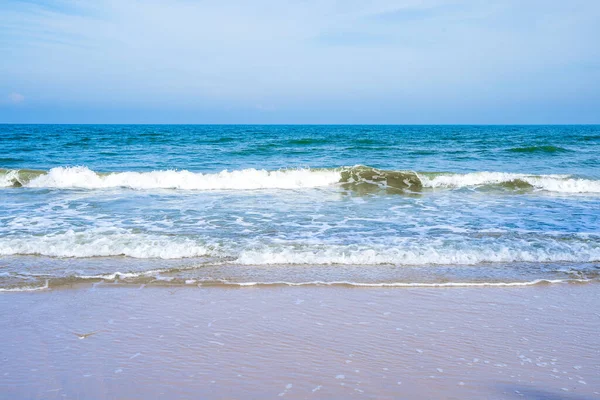 stock image Light blue sea waves on a clean sandy beach.