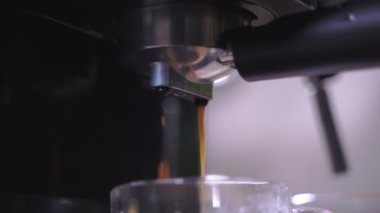 Kahve köpüğüne yakın çekim. Tam otomatik kahve makinesinden çıkan espresso kreması kahve makinesini fincana dönüştürür. yumuşak odak.