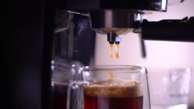 Kahve köpüğüne yakın çekim. Tam otomatik kahve makinesinden çıkan espresso kreması kahve makinesini fincana dönüştürür. yumuşak odak.